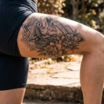 Kobieta prezentująca duży tatuaż na zewnętrznej stronie uda.