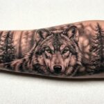 Realistyczny tatuaż, czarno szary portret wilka na przedramieniu