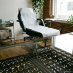 Wnętrze studia piercingu. Na pierwszym planie gablota z szerokim wyborem biżuterii tytanowej i złotej do uszu