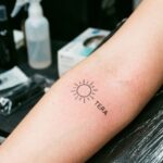 Zbliżenie na bardzo mały, minimalistyczny tatuaż na przedramieniu