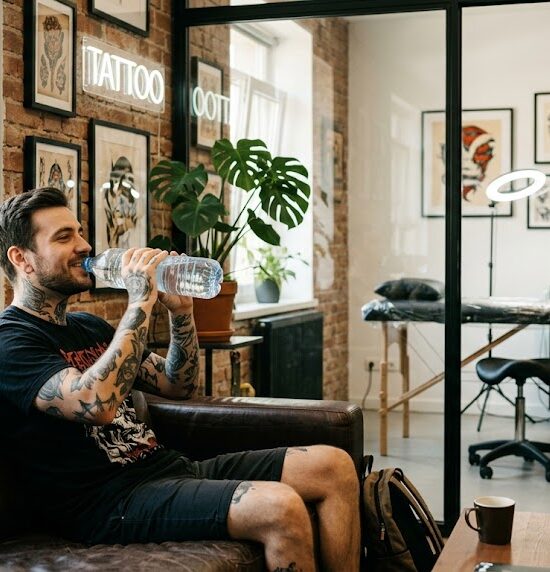 Kadr pokazujący wyluzowanego klienta siedzącego w poczekalni studia tatuażu.